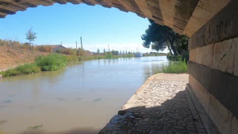 towpath-under-a-bridge-on-The-Canal-Du-Midi-France-at-the-village-of-Le-Somail