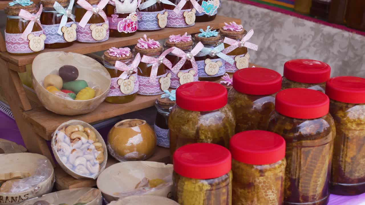 Artisanal vendor stall in rural Honduras displays a vibrant array of honey jars, fruit jellies, and handmade treats