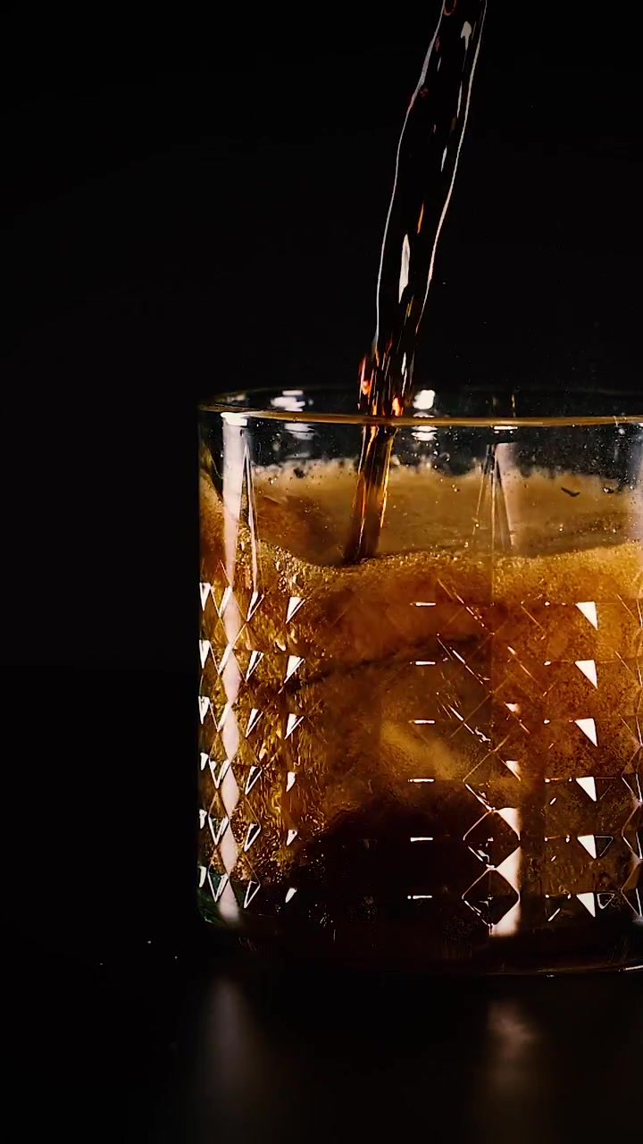 Cola versata sul ghiaccio in un bicchiere