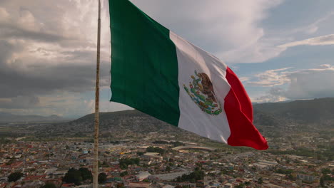 Echte-Mexikanische-Flagge-Weht-Auf-Einem-Hügel-In-Einer-Mexikanischen-Stadt-Oaxaca-Bei-Dramatischem-Sonnenuntergang