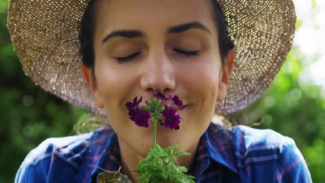 woman smelling flower in garden