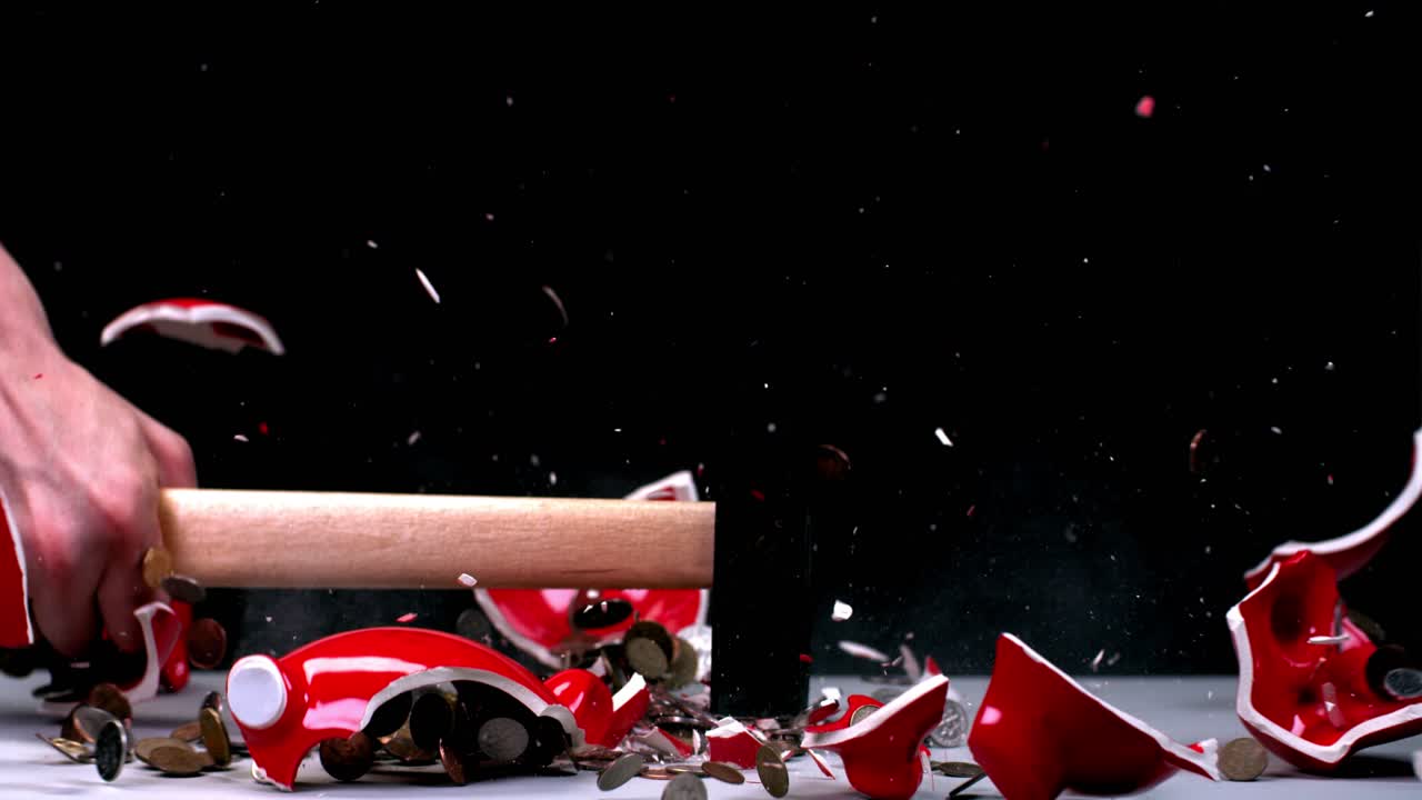 rompiendo una alcancía con un martillo