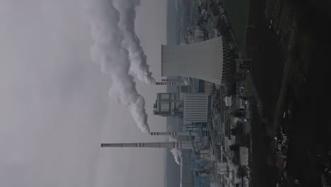 Vertical-shot-of-a-coal-fired-power-plant-with-smoking-chimneys