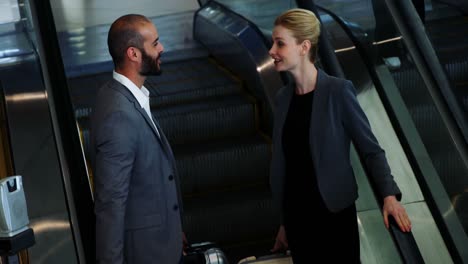 Business-people-interacting-on-an-escalator