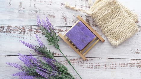 lavender soap bar on wooden dish with lavender flowers and soap bag