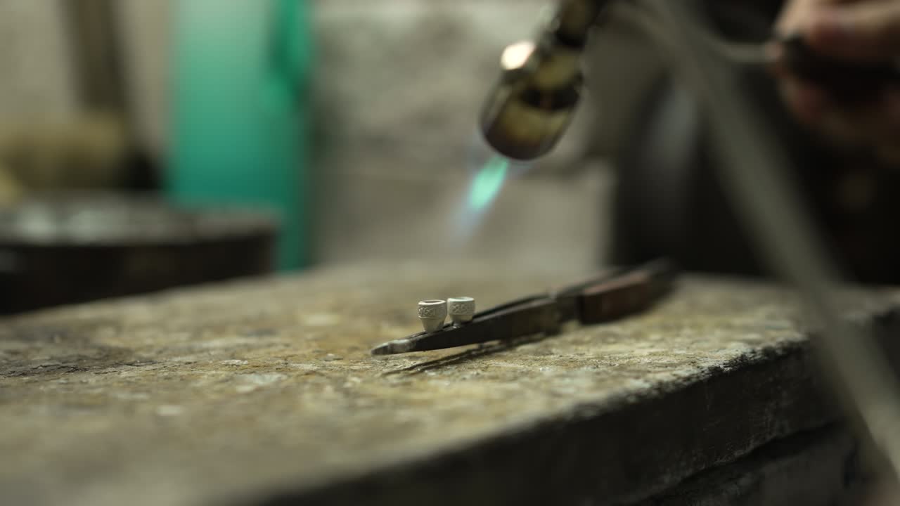 Gioielliere al lavoro in gioielleria. Banco da lavoro per la creazione di gioielli artigianali con strumenti professionali. Primo piano degli strumenti. Thailandia.