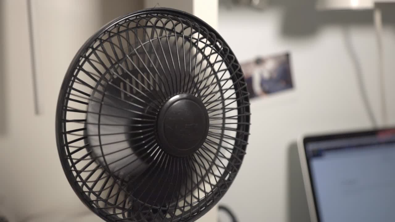 A Person Hand Turning On The Portable Mini Electric Fan - Closeup Shot