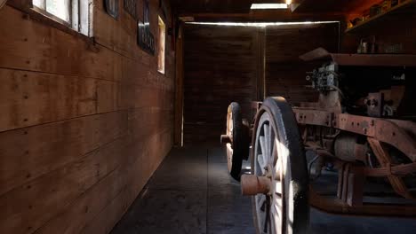 panning-shot-inside-of-an-old-vintage-tracker-inside-of-a-barn-garage-with-sunlight-peaking-in-through-small-windows