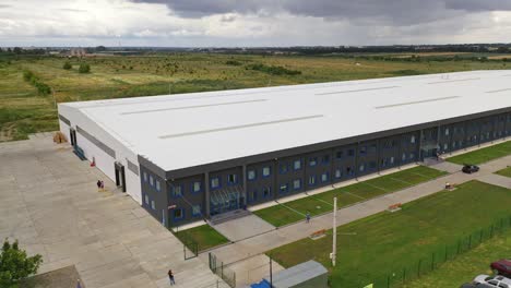modern industrial exterior. large factory building among green fields. new building from outdoors. aerial view.