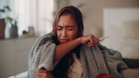 woman coughing and holding a thermometer