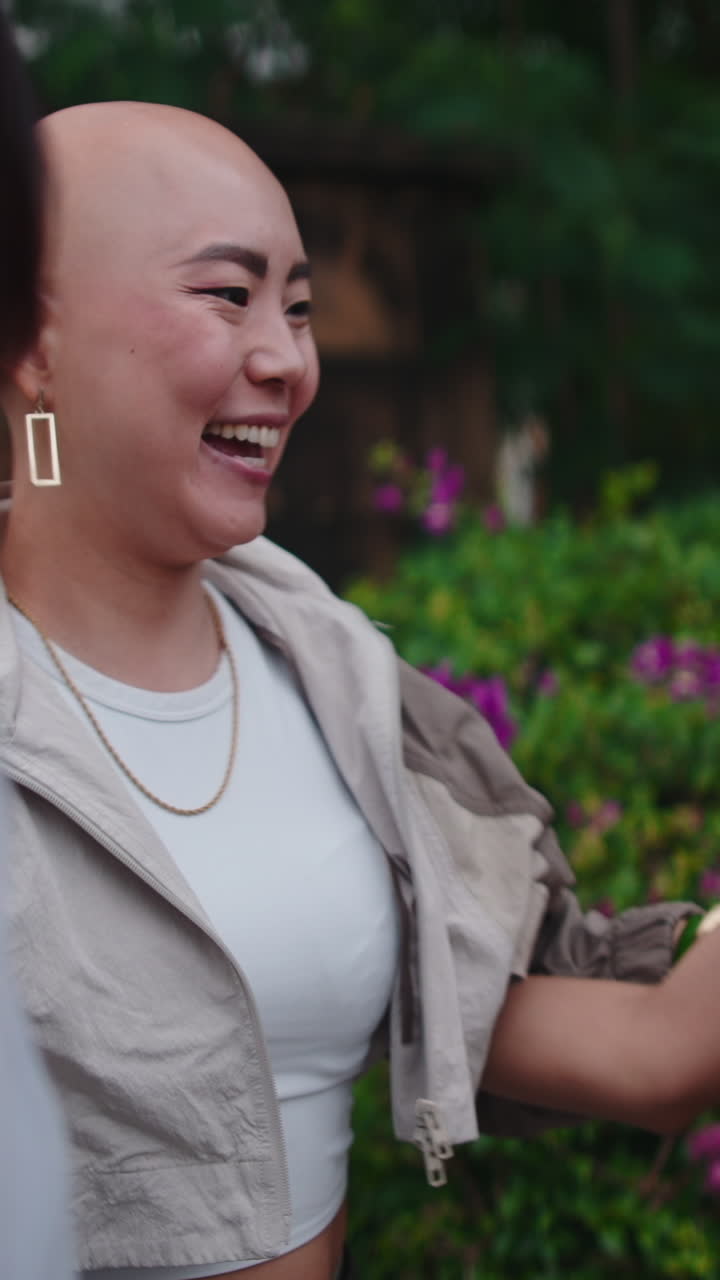 A happy bald woman hugging friends