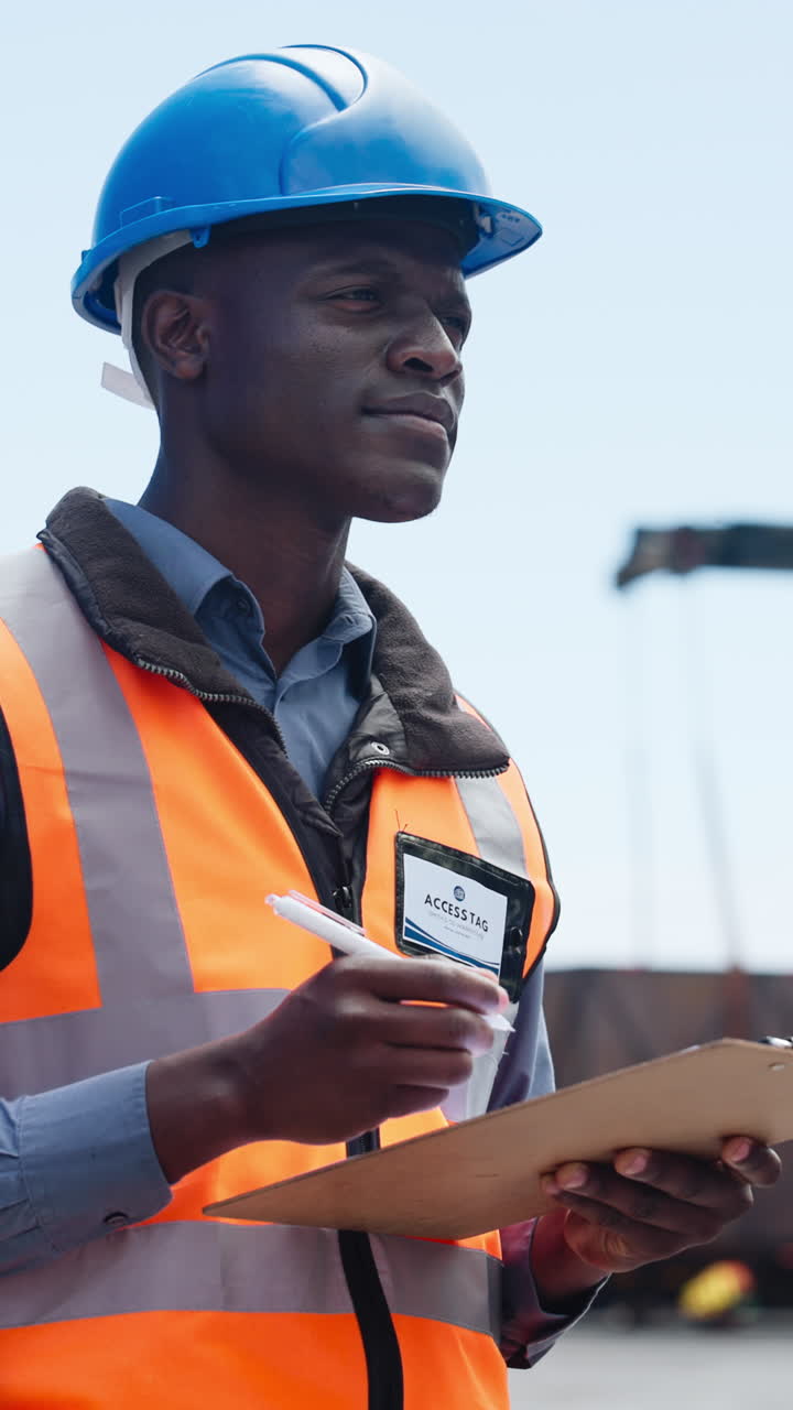 Focused Worker in Hard Hat and Safety Vest Writing on Clipboard