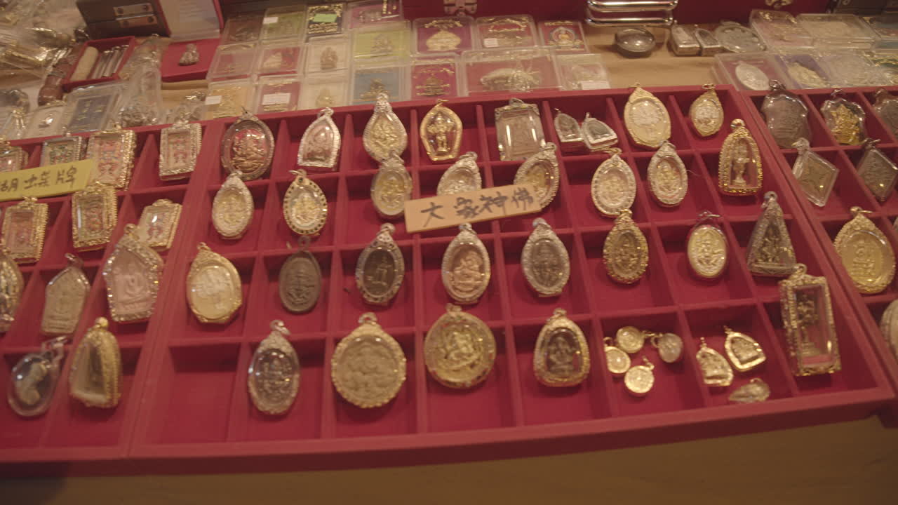 Holy amulets made of gold in a street market in Thailand, Asia