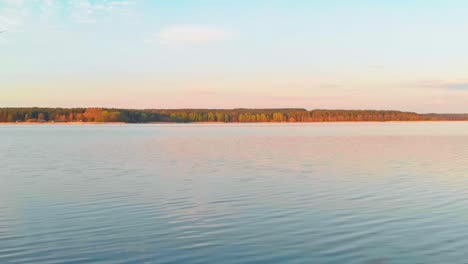 fixed shot of long rocky bay on blue calm water lake, jugla, riga, latvia