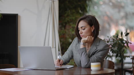 portrait of ambitious muslim business woman working with laptop indoors at home concentrated on modern technology. indian businesswoman working on laptop sit at workplace at home or office room