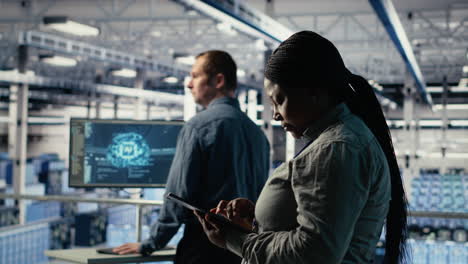 team of data center technicians checks ai dashboard using laptop