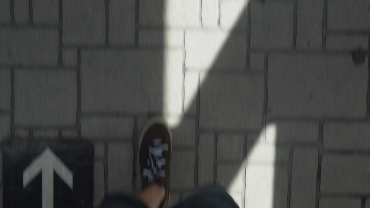 View of shoes walking down a street with arrows on the street pointing up in Osaka, Japan.