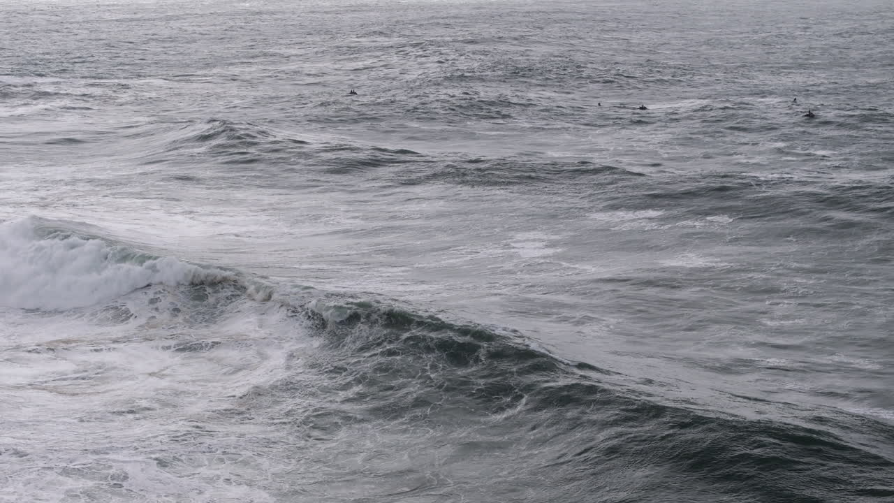 Jet ski teams observing giant Nazaré rollers aerial view. Portugal, Europe, professional tow-in surfing