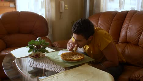 young male eating a pancake in a living room