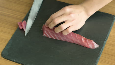 slowly and precisely slicing fish meat