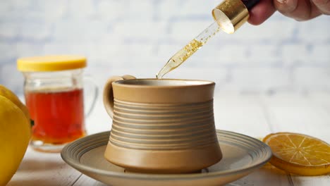 adding honey and edible gold to a cup of lemon tea