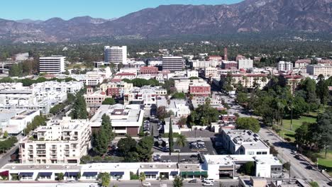 drone shot of pasadena neighborhood district apartment buildings next to central park with mountains in background, panning