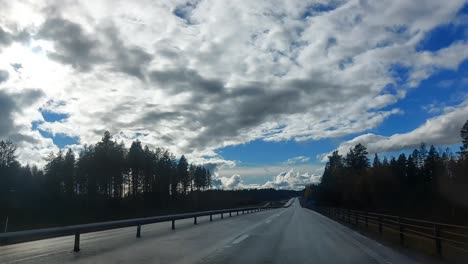 conduciendo por una carretera sueca bajo un hermoso paisaje nublado