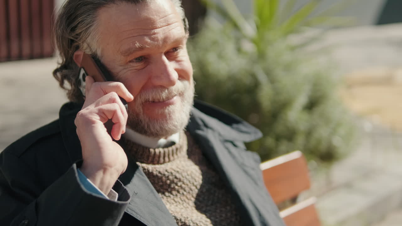 Voksen mann som snakker i telefonen i parken
