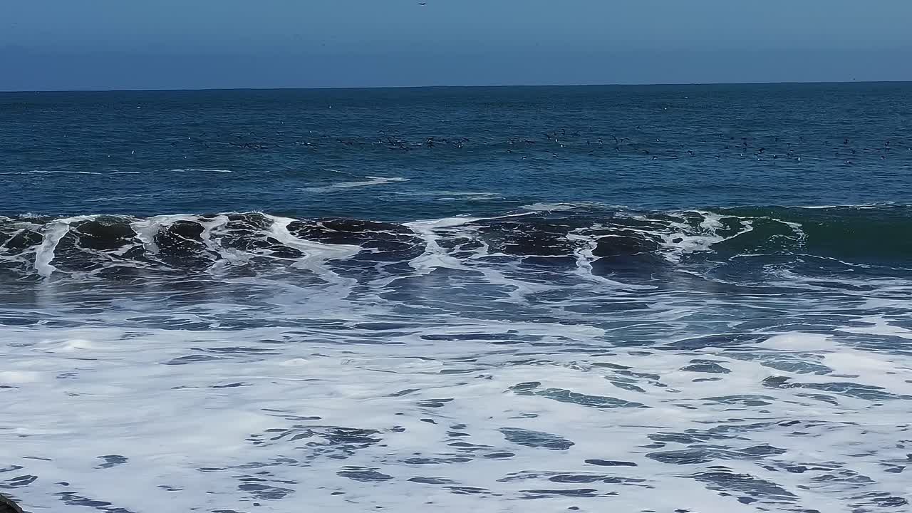 Le onde si infrangono sulla costa in Cile durante una giornata di sole splendente