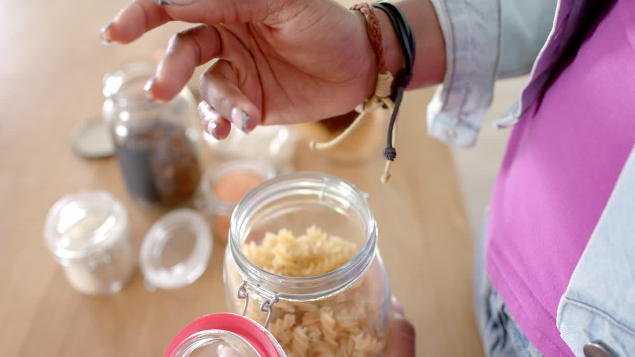 Opening jar of pasta, woman preparing ingredients in kitchen with smile