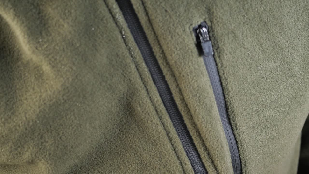 persona cerrando una chaqueta de lana