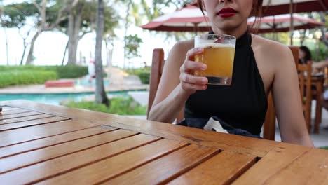 person sipping a drink at an outdoor table