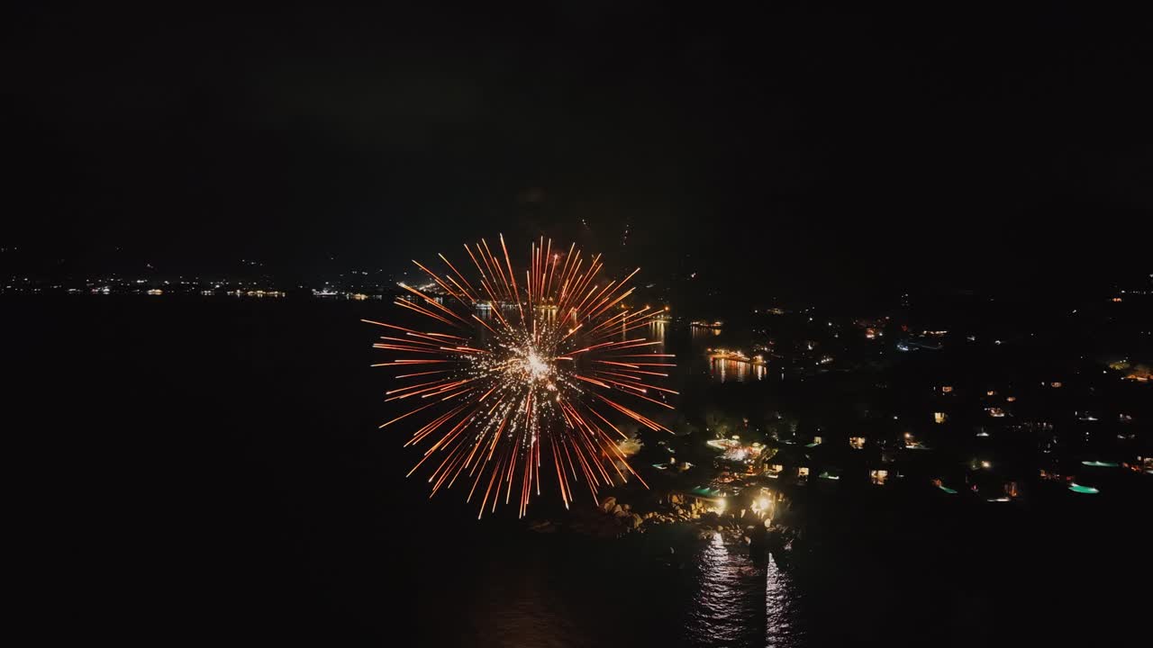Stunning aerial view of colorful fireworks exploding over the coastline of Koh Samui, at night. Bright celebration lights reflected on the water, festive atmosphere, ideal for New Year, holiday, event