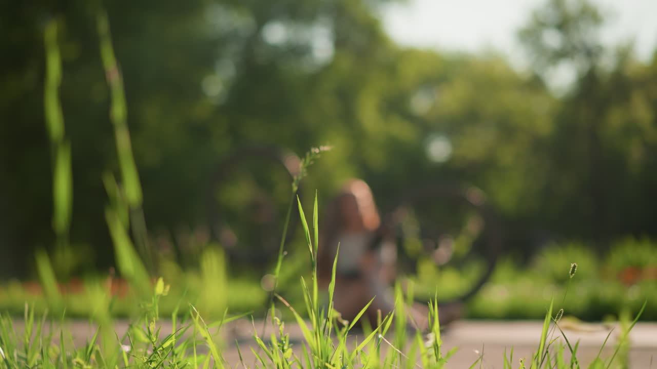 울창한 초록색과 나무로 둘러싸여 평온한 분위기를 조성하는 그녀의 거꾸로 된 자전거 에 앉아있는 여자의 흐릿한 시각