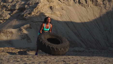 girl in sportswear pussh a tire. street workout.