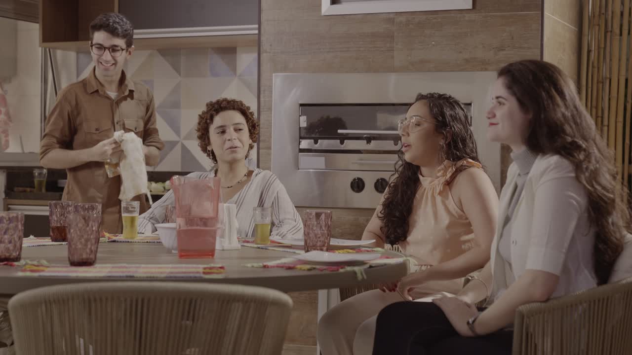 A group of friends gathering for a meal and drinks, toasting and laughing