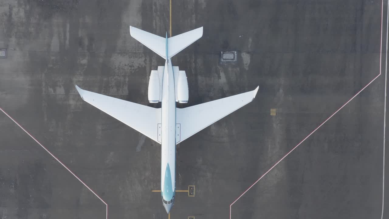 gulfstream g550 стоит без движения на сером асфальте аэродрома, аэрофотосъемка