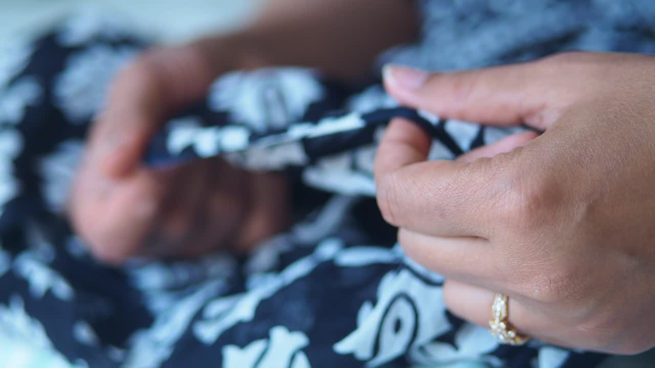 Woman's Hands Holding and Feeling Black and White Patterned Fabric