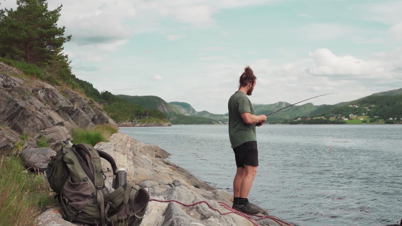 retrato de un hombre atrapando peces con una caña de pescar en la entrada de pevika en indre fosen, noruega