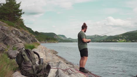 portrait of a man catching fish with fishing rod at pevika inlet in indre fosen, norway