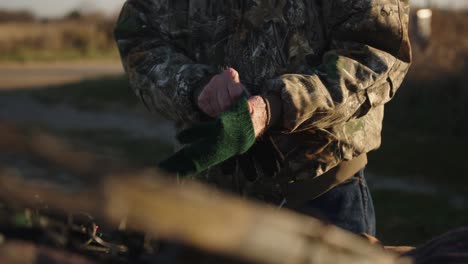 hunter puts on glove during hunting season