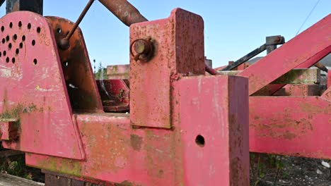 Old-farm-equipment-overgrown-and-lying-abandoned-in-a-farmyard