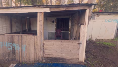 Escena-De-Una-Casa-Antigua-En-Los-Suburbios,-Estructura-Deteriorada-Y-Desgastada-Por-El-Tiempo,-Silla-De-Plástico-Y-Antigua-Casa-De-Pescadores