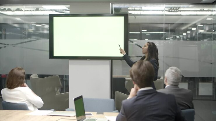 Confident speaker talking and pointing at display