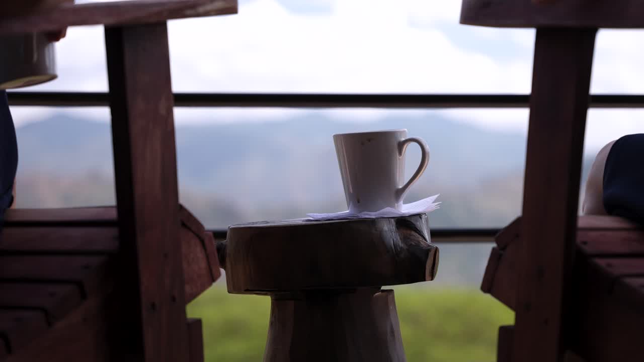 una pareja disfruta del café por la mañana desde un hermoso balcón con vistas a las montañas