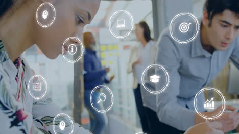 animación de iconos digitales contra mujer biracial usando brújula trabajando en un plan modelo en la oficina