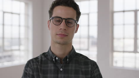 retrato de un atractivo joven hipster con gafas sonriendo confiado disfrutando de un estilo de vida exitoso moviéndose hombre independiente en el fondo de las ventanas del apartamento