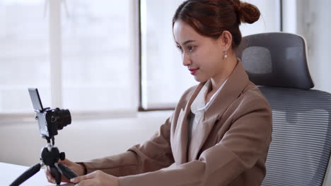 a female social media influencer is preparing for her podcast inside her office.