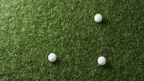 Close-up-of-golf-balls-on-grass,-copy-space,-slow-motion