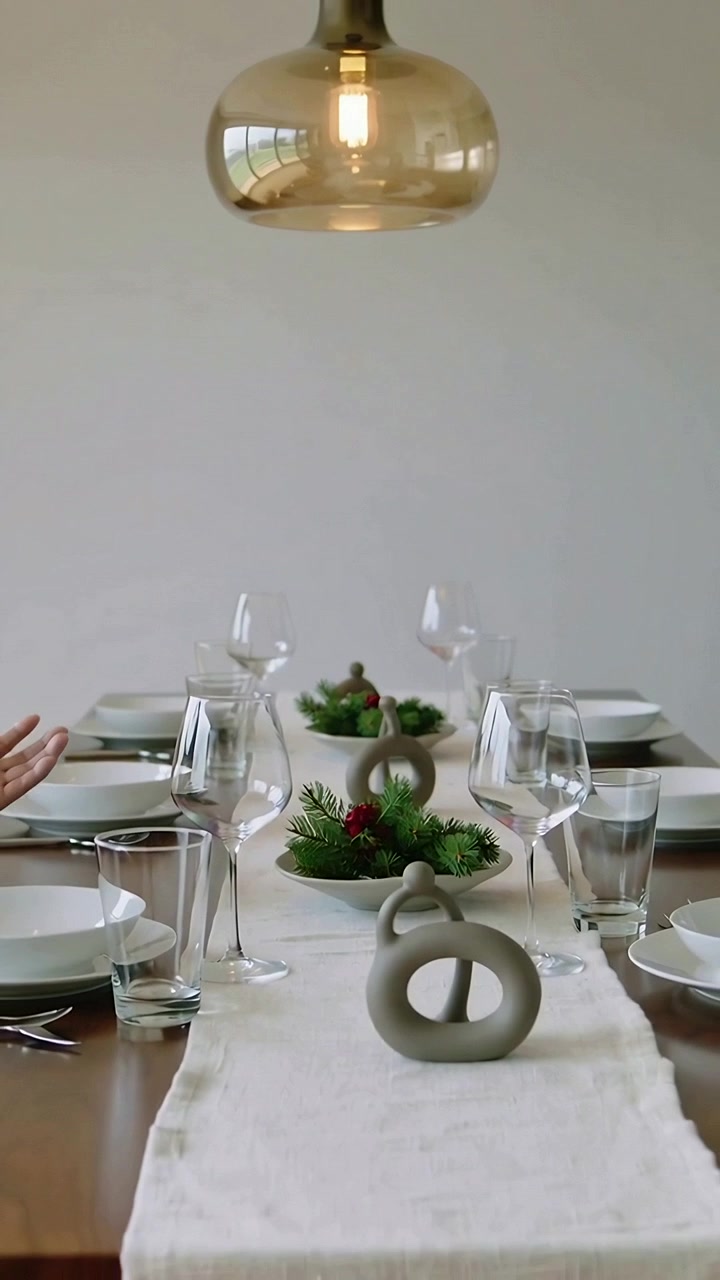 Vertical video: Entering man in dark top inviting guests gesturing at ceramic loops on dining table